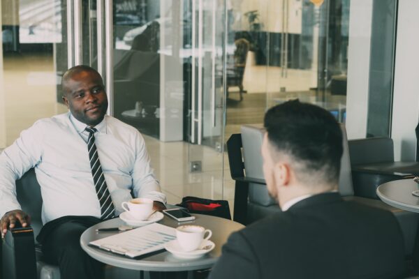 Two businessmen talking at a cafe table.